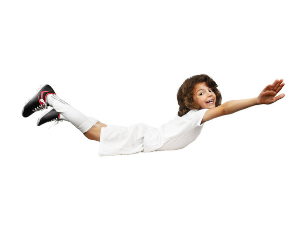 Smiling little boy in football uniform with arms raised simulating flight against a white background. Isolated on white. Copy space - Photo, Image