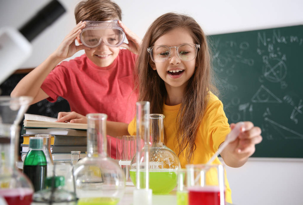 Smart pupils making experiment in chemistry class - Фото, зображення