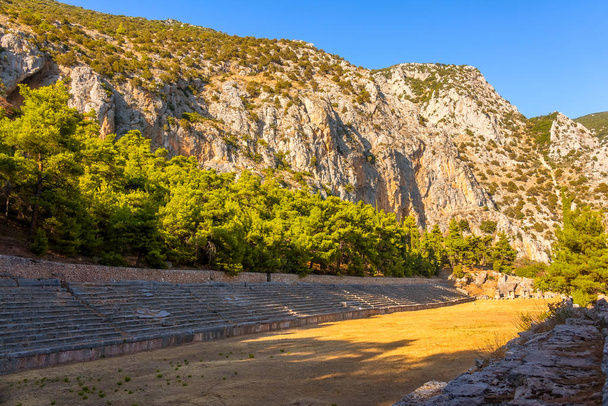 Greece. Delphi. A small ancient stadium at the foot of the mountain. Summer sunny day - Zdjęcie, obraz