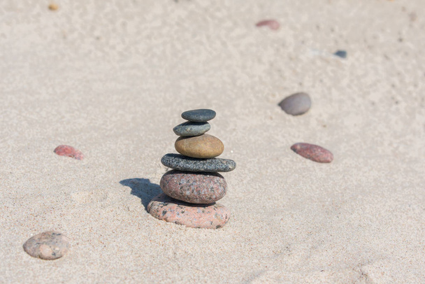 Egy halom kő a homokos parton, közel a tengerhez. Zen kert. Kavicstorony. - Fotó, kép