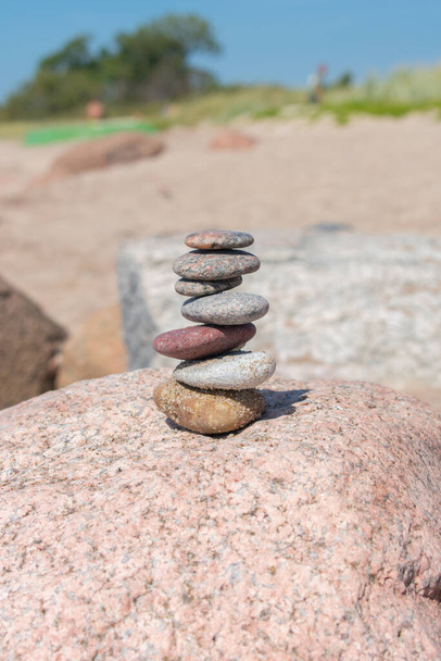 Stack of stones on sand beach near sea. Zen garden. Pebble tower. - Photo, Image