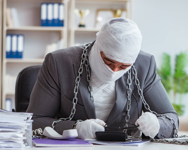 Bandażowany pracownik biznesowy pracujący w biurze wykonujący papierkową robotę - Zdjęcie, obraz
