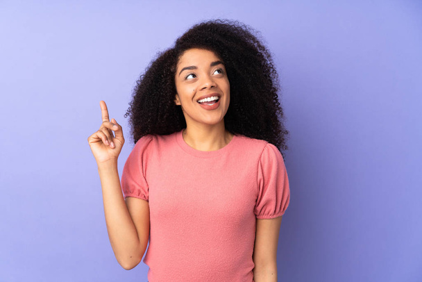 Young african american woman isolated on purple background intending to realizes the solution while lifting a finger up - Photo, image
