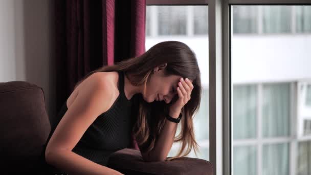 Smutná žena pláče na pozadí okna 4k - Záběry, video