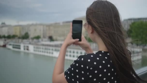 Meisje dat stadsfoto 's maakt vanaf de brug. Budapest, Hongarije - Video