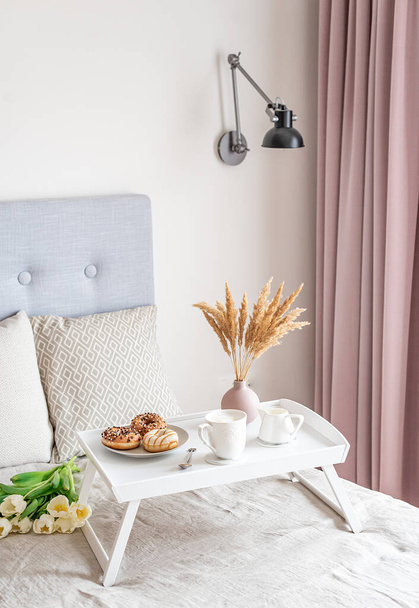 Café da manhã na cama, xícara com cappuccino, donuts, flores tulipas brancas, conceito da manhã, lençóis de linho, dia da mulher
 - Foto, Imagem