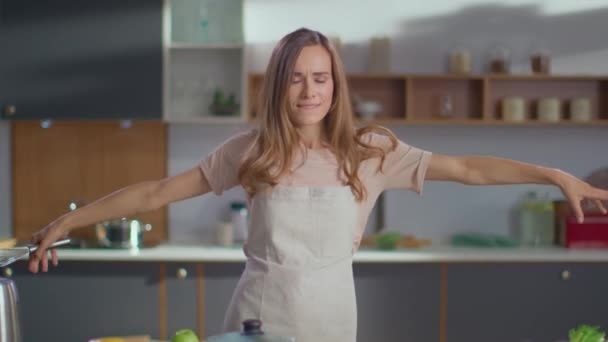 Cheerful woman dancing on kitchen. Housewife having fun at home - Filmati, video