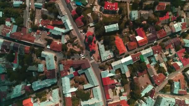 Съемка с воздуха улиц, блоков и крыш домов в городском пейзаже в солнечный летний день с вращающейся камерой
. - Кадры, видео