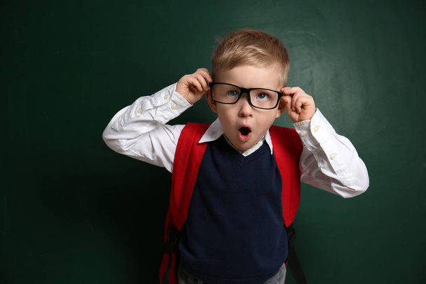 Funny little child wearing glasses near chalkboard. First time at school - Photo, image