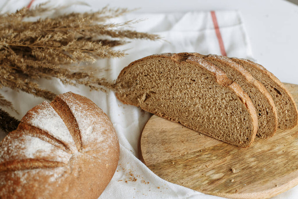 Нарізаний хліб на дошці на білій скатертині
 - Фото, зображення