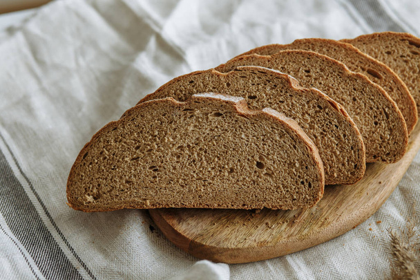 Sliced bread on a board on a white tablecloth	 - Foto, Bild