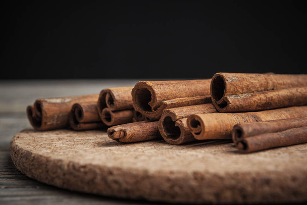 Cinnamon sticks on wooden background. creative photo - Zdjęcie, obraz