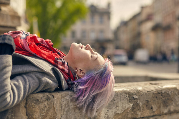 confident woman lying on stairs in spring on the street . - Foto, Imagen