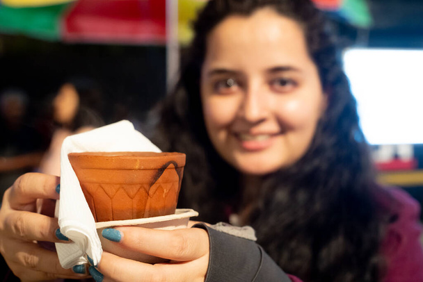 Fiatal indiai lány kezében egy cserépedény agyag cserép tandoori chai tea vagy kávé - Fotó, kép