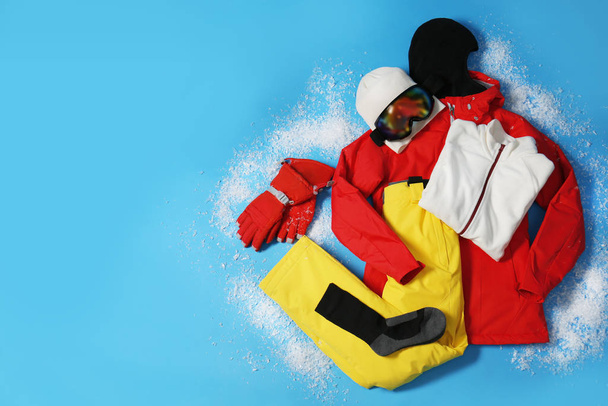 Stylish winter sport clothes on light blue background, flat lay. Space for text - Foto, Imagem