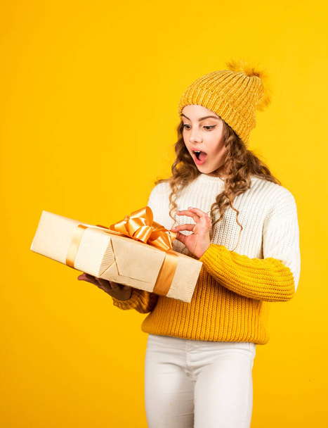 Received parcel. Shopping find perfect gift. Cute kid enjoy shopping. Shopping addict with present wrapped box. Fashionable teen girl after shopping gift. Small child holding box yellow background - 写真・画像