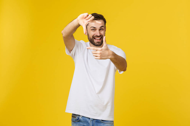 Handsome Irish redhead man with beard wearing glasses over yellow isolated background smiling making frame with hands and fingers with happy face. - Фото, зображення