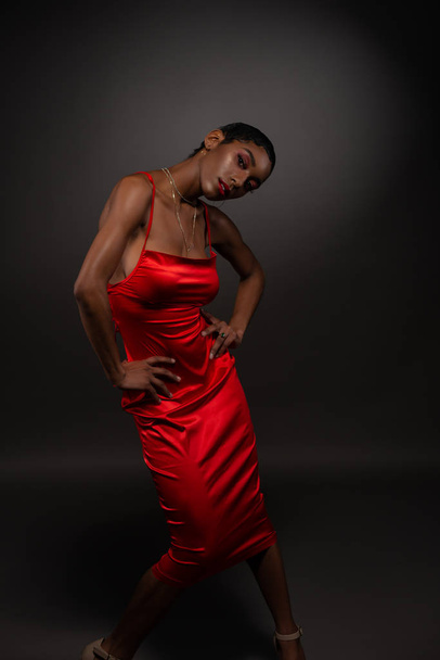 Slender young African American woman in a tight red dress - Fotoğraf, Görsel