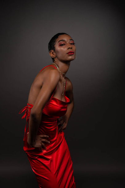 Slanke jonge Afro-Amerikaanse vrouw in een strakke rode jurk - Foto, afbeelding