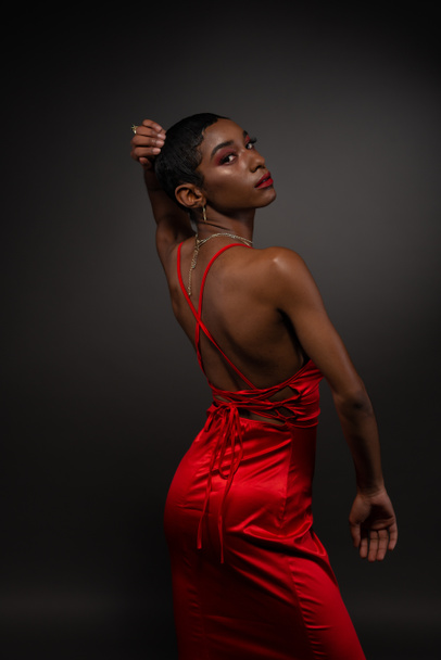 Slender young African American woman in a tight red dress - Фото, изображение