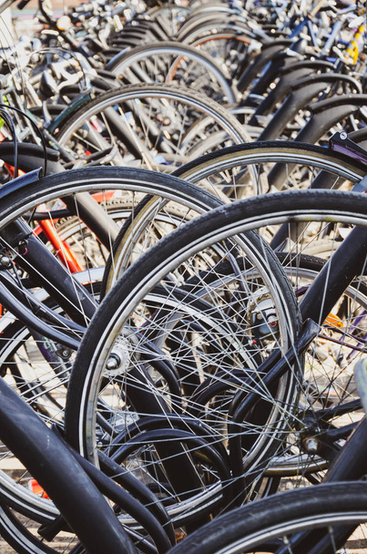 Λεπτομέρεια από τις ρόδες του ποδηλάτου που σταθμεύουν στο Venlo, Limburg, Ολλανδία. Κλείσε κάθετη φωτογραφία. Ολλανδικό πάρκινγκ ποδηλάτων. Ποδηλασία πόλης. Οικολογικά μέσα μεταφοράς. - Φωτογραφία, εικόνα