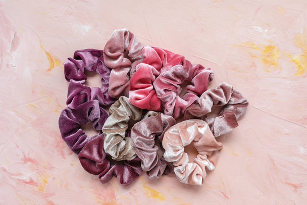 Colección de scrunchies de terciopelo de moda sobre fondo rosa
 - Foto, Imagen