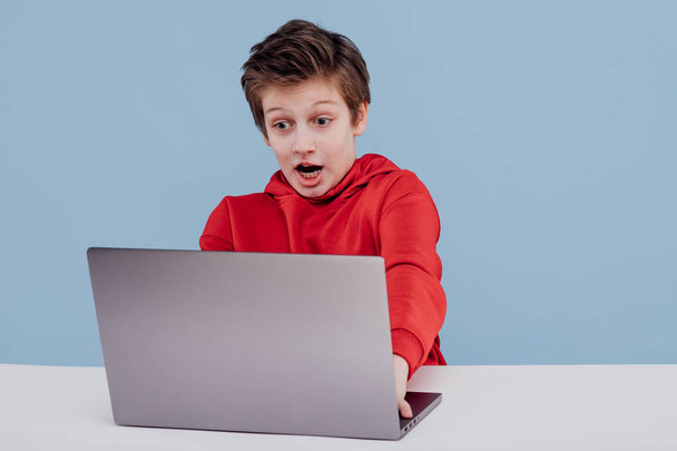 Excited boy using laptop in studio - Foto, imagen