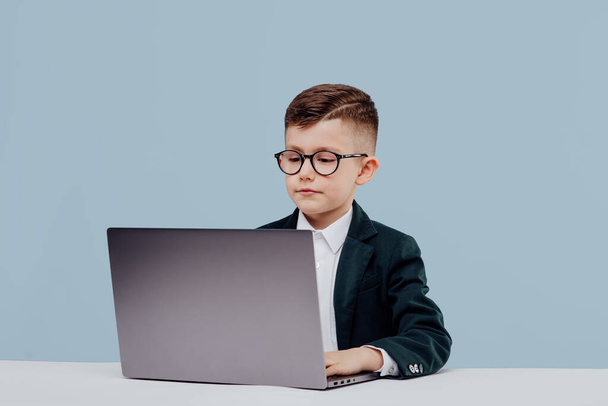Young business boy. with glasses using a laptop - Zdjęcie, obraz