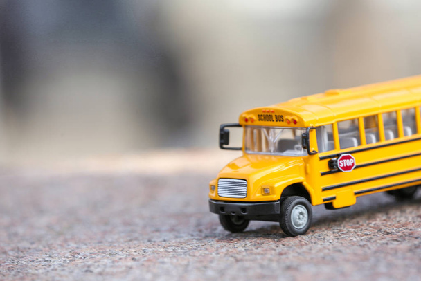 Yellow toy school bus on road outdoors. Student's transport - Foto, Imagen