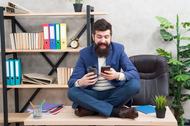 Take break to check social networks. Online relax. Self care. Relaxation techniques. Mental wellbeing and relax. Man bearded manager formal suit sit lotus pose relaxing. Application smartphone - Foto, Bild