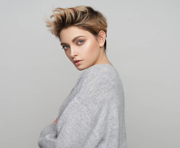 Portrait of sexy woman with short blonde hair on gray background - Fotó, kép