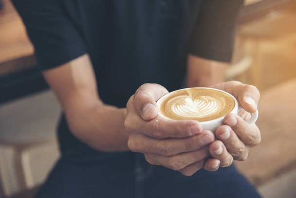 Késői művészet egy csésze kávé barista kézen. fiatal hipster szerelem kávé - Fotó, kép