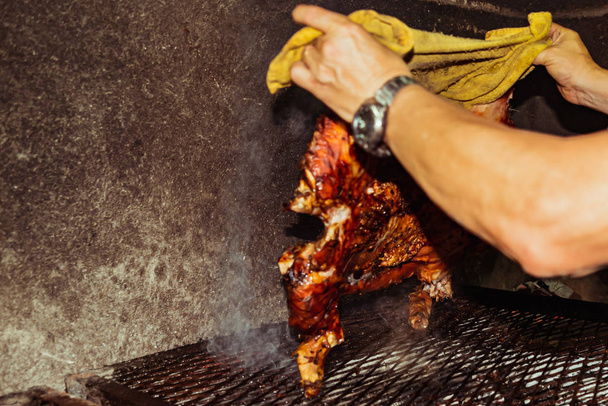 Cerdo tradicional cocinado en la parrilla de carbón. El cerdito está asado entero en una fogata. Cerdo orgánico en la saliva
. - Foto, Imagen