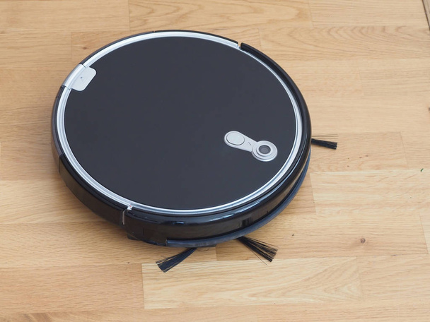 working Black Robotic Vacuum Cleaner with smart laminate and wood floor cleaning technology - Photo, Image