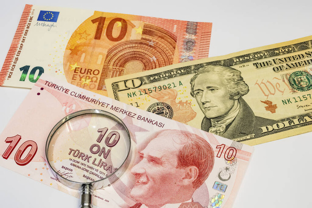 közeli amerikai dollár, török líra és eurobankjegyek nagyítóval fehér alapon - Fotó, kép