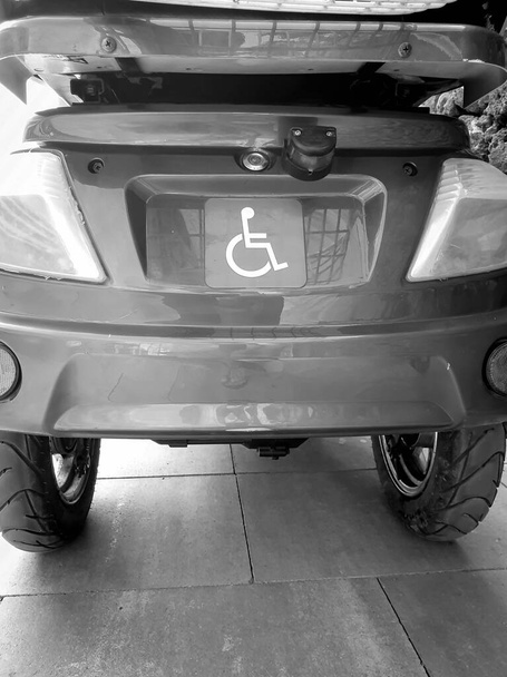 Yaya yolundaki engelliler için elektrikli sandalyenin siyah ve beyaz görüntüsü - Fotoğraf, Görsel