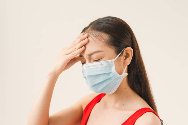 Aasian naiset käyttävät naamioita suojellakseen tautia ja päänsärkyä virukselta valkoisella taustalla
. - Valokuva, kuva