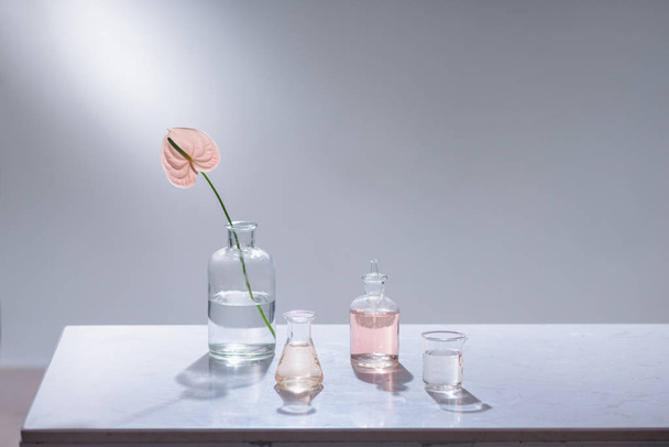 Beautiful composition with perfume samples and flowers on table - Foto, afbeelding