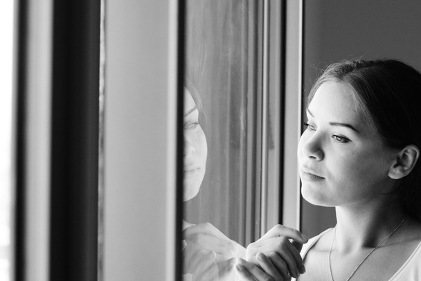 beautiful woman stands in front of the window - Foto, afbeelding