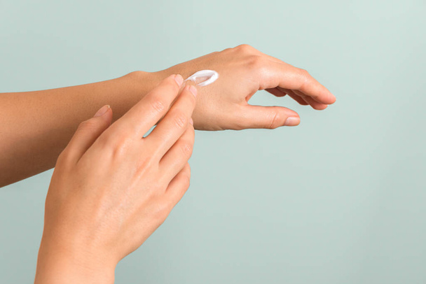 closeup of tender hands of a young woman with moisturizer on. spring skin protection - Foto, imagen