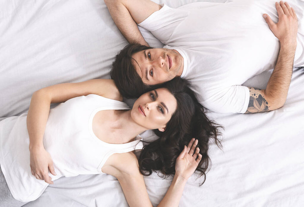 Životní styl portrét mladého páru ležícího v posteli - Fotografie, Obrázek