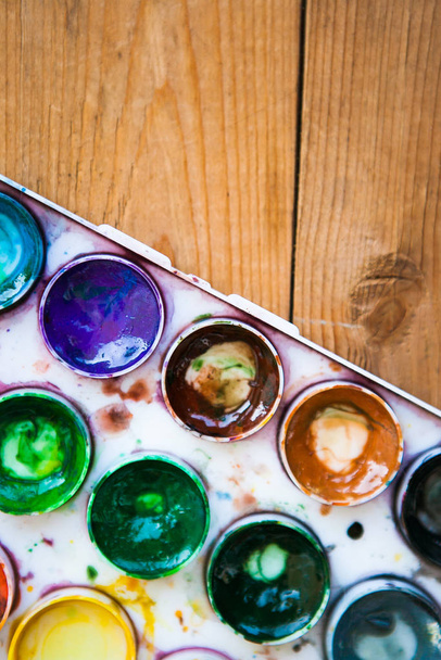 Set of multicolored watercolor paints on the wooden background - Foto, Imagem