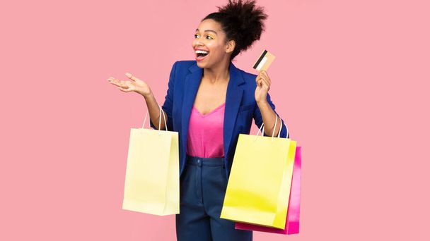 Portrait of cheerful afro girl holding shopping bags looking away - Fotoğraf, Görsel