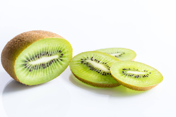 Mitad de fruta kiwi y rodajas aisladas sobre fondo blanco con enfoque selectivo - foto horizontal
 - Foto, imagen