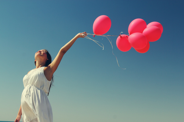 Young pregnant woman holding red balloons - Photo, Image