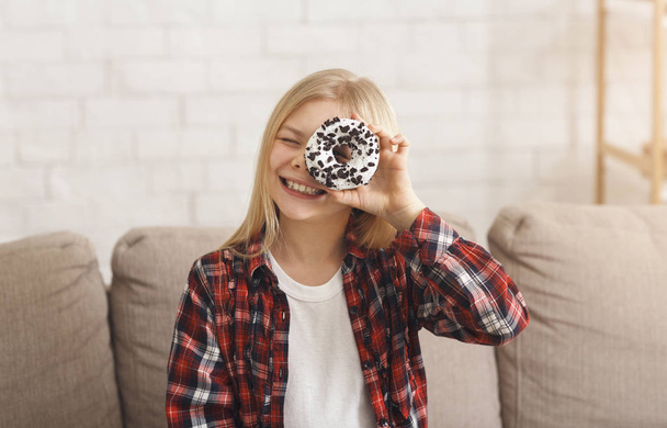 Girl Looking Through Donut At Camera Sitting On Couch Indoor - Fotografie, Obrázek