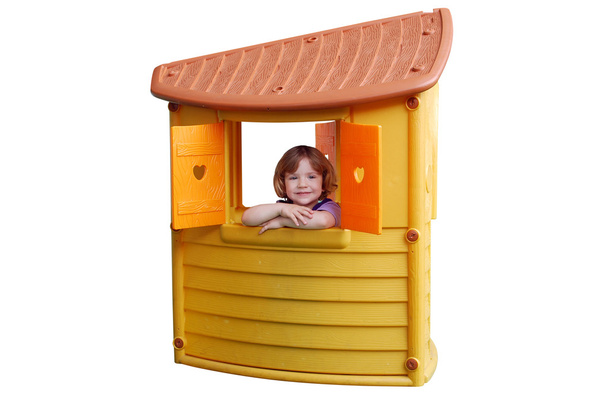 klein meisje in playhouse speelgoed geïsoleerd - Foto, afbeelding