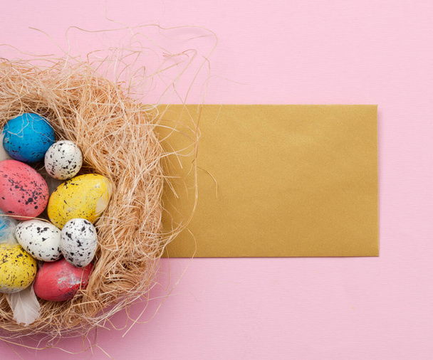 Uova di Pasqua in nido e biglietto di auguri su sfondo rosa
 - Foto, immagini