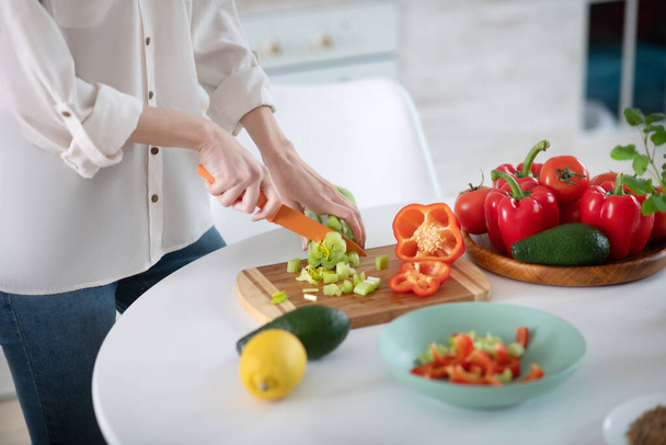 Female hands slicing salad on a cutting board. - Valokuva, kuva