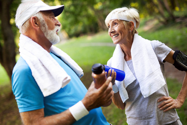 Beautiful senior couple jogging in nature living healthy - Photo, image